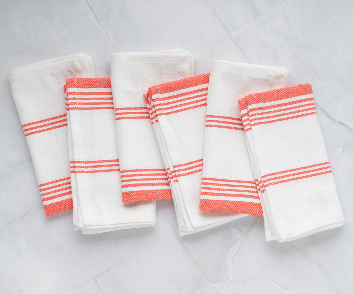 Vibrant orange napkins, adding a pop of color to the table arrangement. Vibrant orange napkins, adding a pop of color to the table arrangement.
