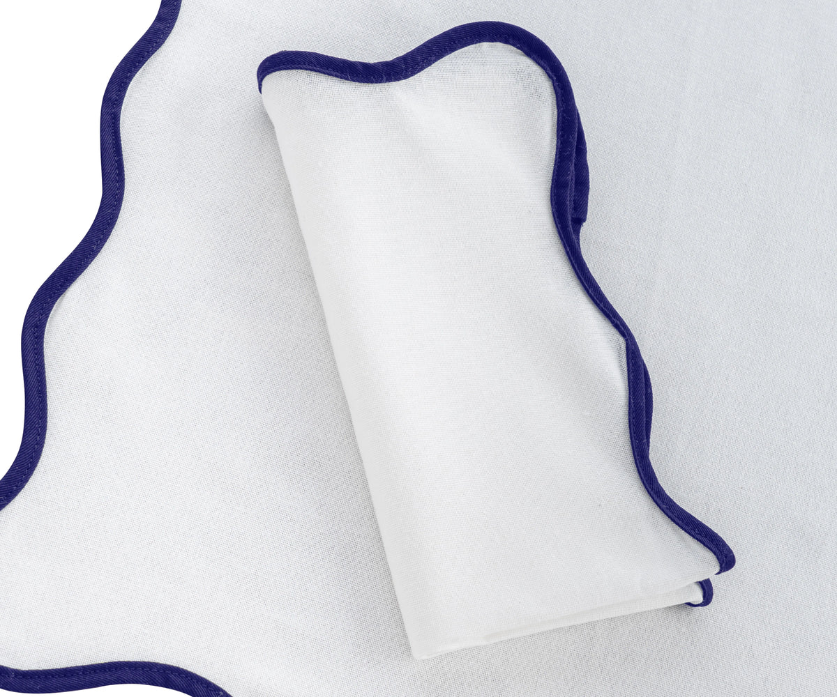 Soft navy blue linen scalloped napkins  for a refined dinner setup. Soft navy blue linen scalloped napkins  for a refined dinner setup.