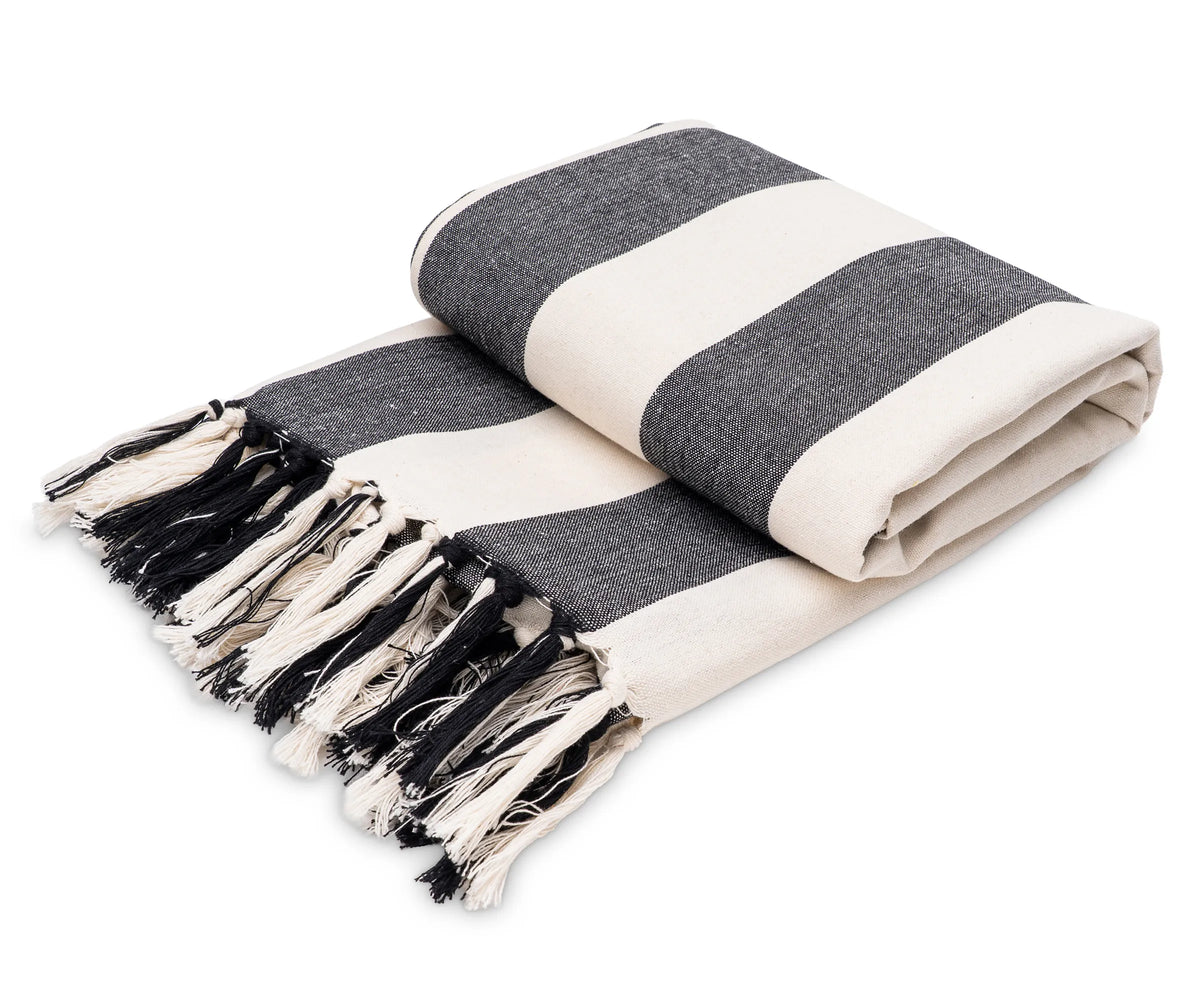 Black and white striped cotton throw blanket draped over a sofa for a modern, cozy look Black and white striped cotton throw blanket draped over a sofa for a modern, cozy look