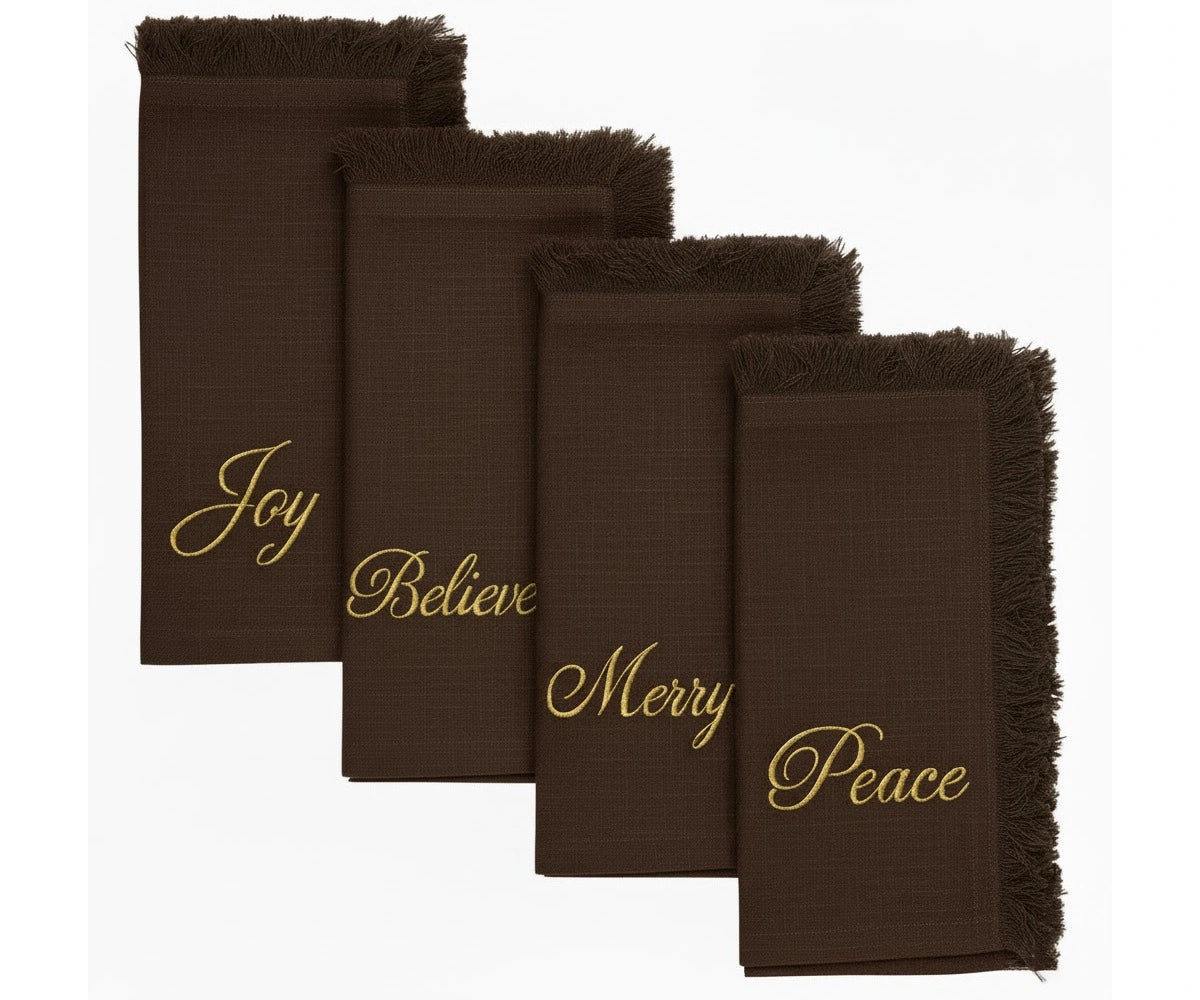 Warm brown embroidered napkins with gold lettering and fringed edges for cozy festive dining Warm brown embroidered napkins with gold lettering and fringed edges for cozy festive dining