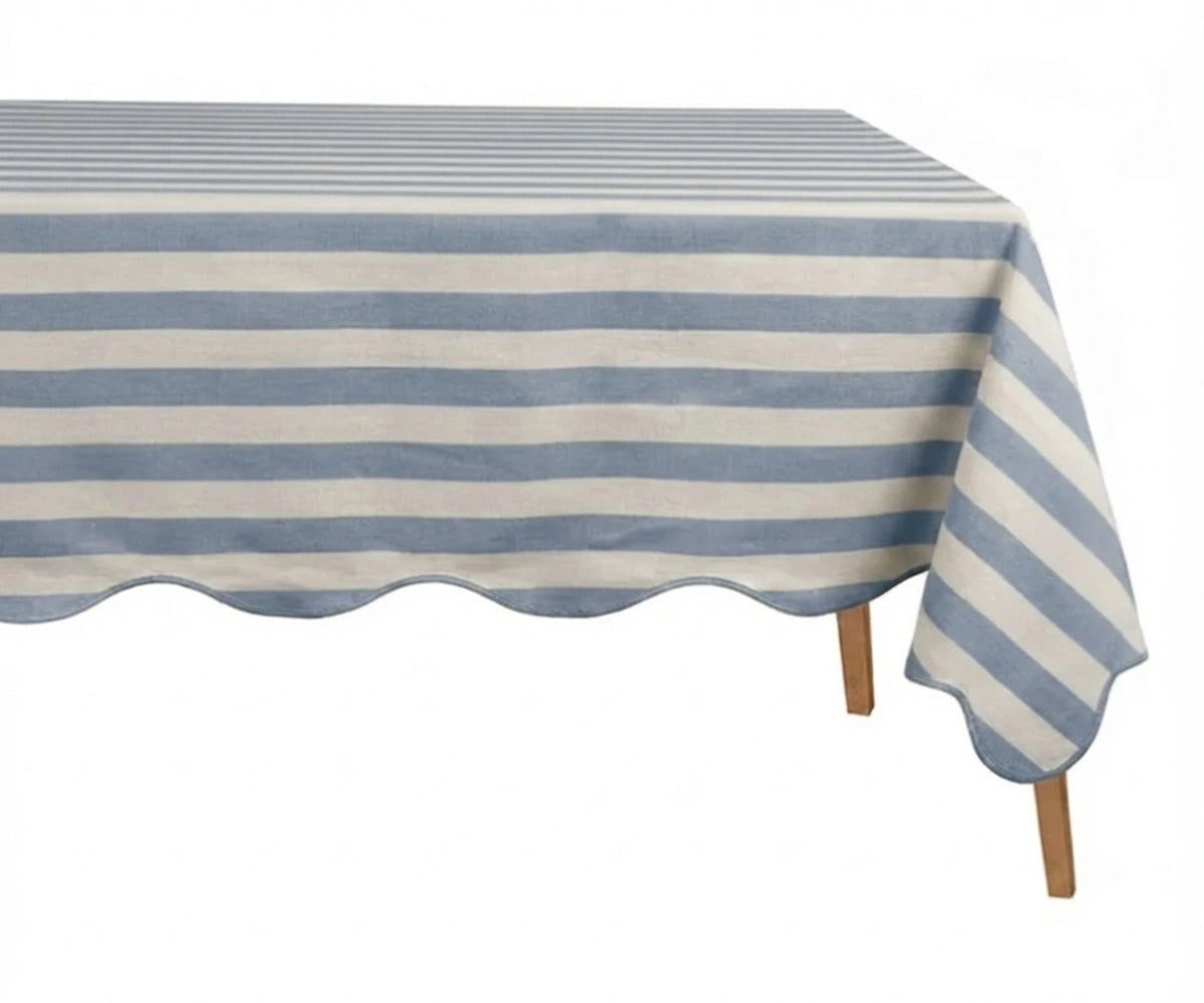 Light Blue and white cabana striped tablecloth with a scalloped edge on a wooden table. Light Blue and white cabana striped tablecloth with a scalloped edge on a wooden table.