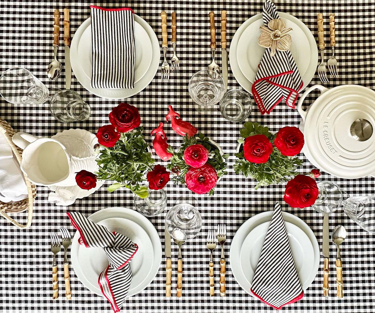 A charming combination of tablecloths graces the table, including a buffalo check, a green plaid, a tablecloth with a plaid pattern, and a timeless black and white plaid, adding flair and character to the setting. A charming combination of tablecloths graces the table, including a buffalo check, a green plaid, a tablecloth with a plaid pattern, and a timeless black and white plaid, adding flair and character to the setting.