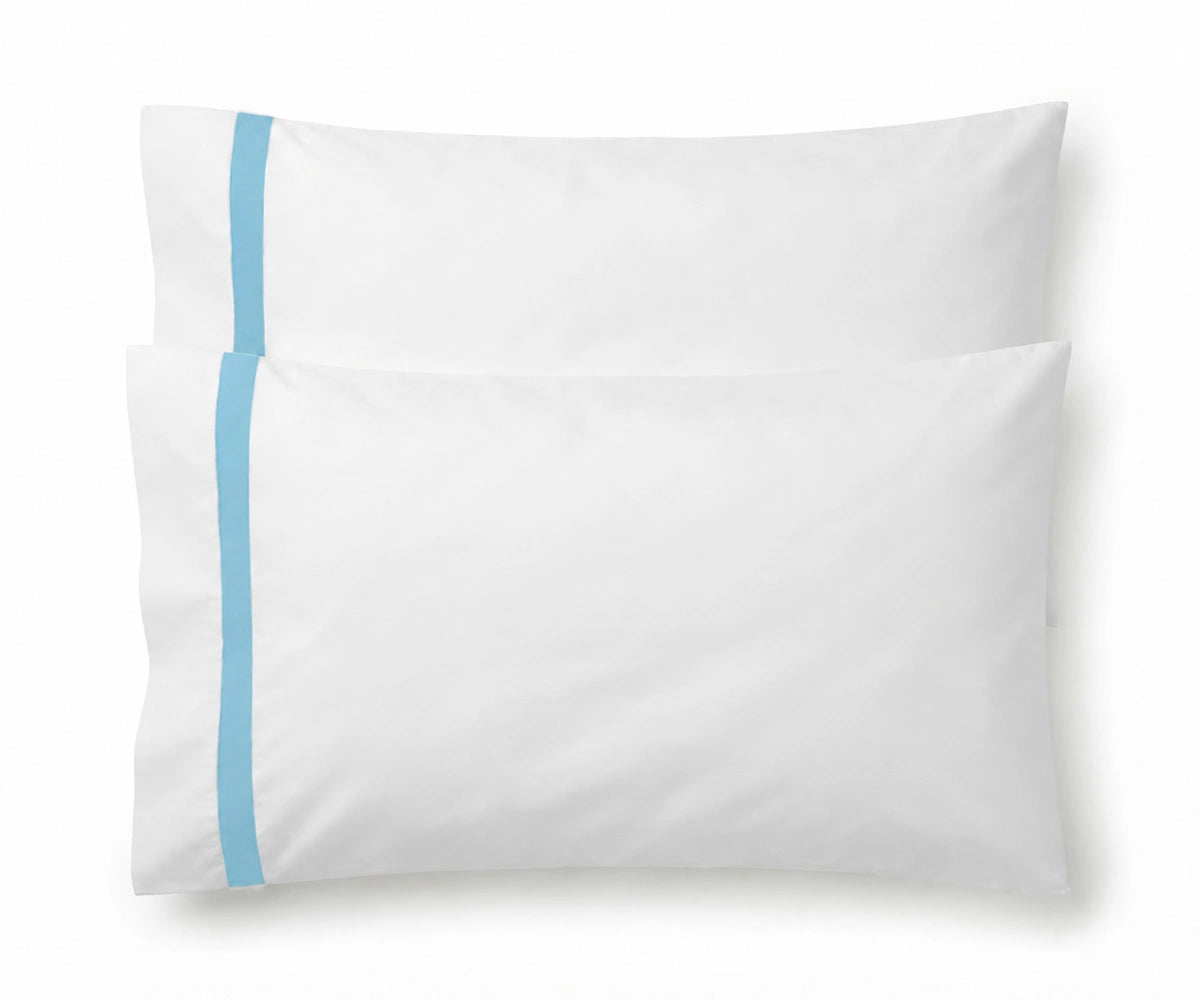 Pair of white cotton pillowcases featuring a single light blue embroidered accent border line. Pair of white cotton pillowcases featuring a single light blue embroidered accent border line.
