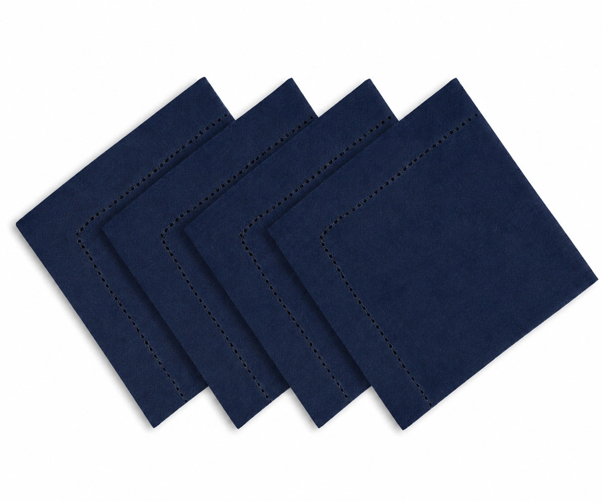 Four navy square cloth napkins with decorative stitched borders, arranged in a cascading stack on a white background. Four navy square cloth napkins with decorative stitched borders, arranged in a cascading stack on a white background.