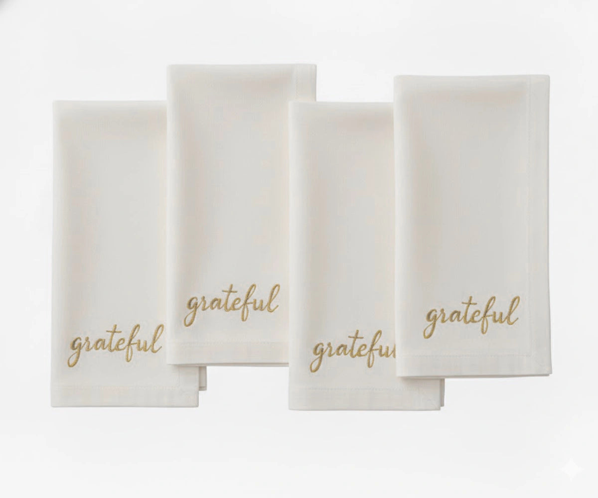Ivory embroidered napkin showcasing “Grateful” in beige thread for elegant table décor. Ivory embroidered napkin showcasing “Grateful” in beige thread for elegant table décor.