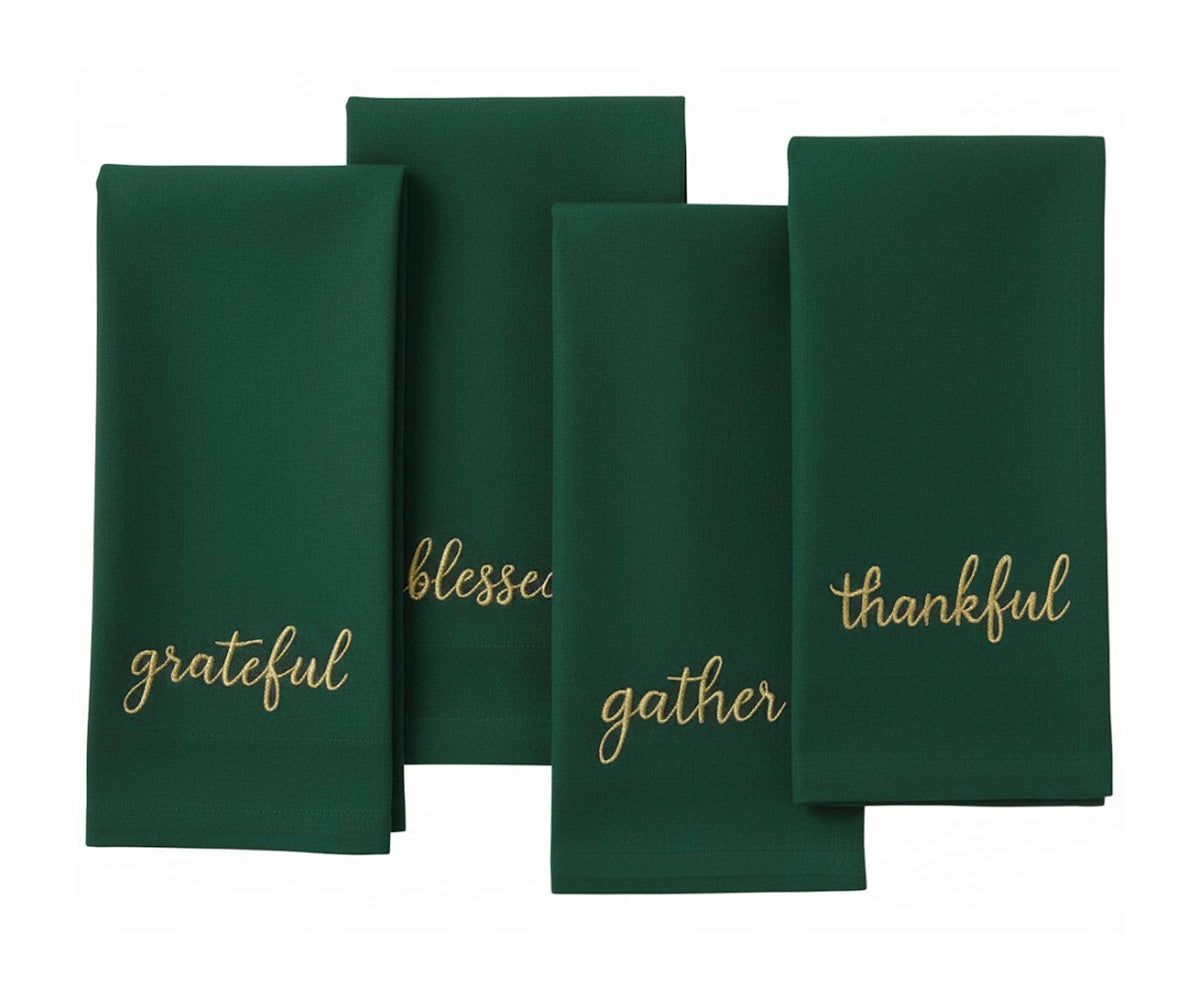Holiday sentiment embroidered napkin in dark green with gold stitching for elegant table settings. Holiday sentiment embroidered napkin in dark green with gold stitching for elegant table settings.
