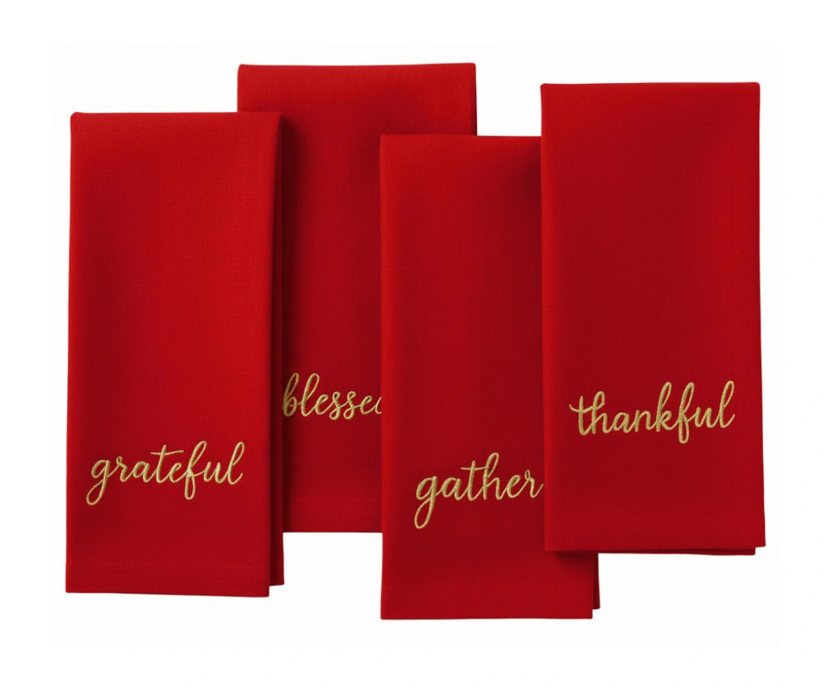 Red holiday napkin with gold embroidered festive words – perfect for Christmas table settings. Red holiday napkin with gold embroidered festive words – perfect for Christmas table settings.