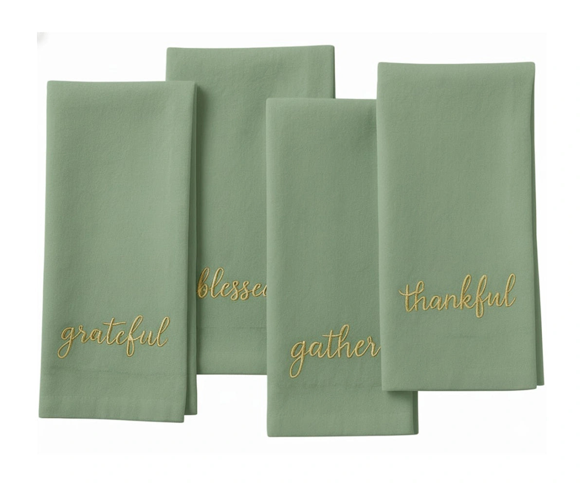 Soft sage green sentiment napkin with gold stitching for festive table décor. Soft sage green sentiment napkin with gold stitching for festive table décor.
