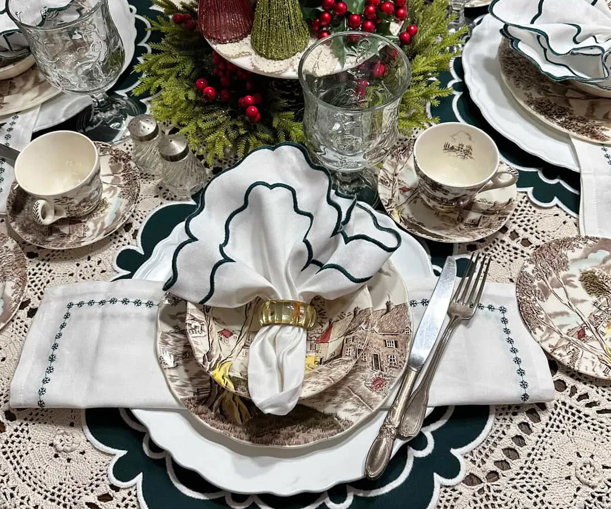 Green scalloped cotton napkins neatly folded on a table, decorative dining linen for modern table settings. Green scalloped cotton napkins neatly folded on a table, decorative dining linen for modern table settings.