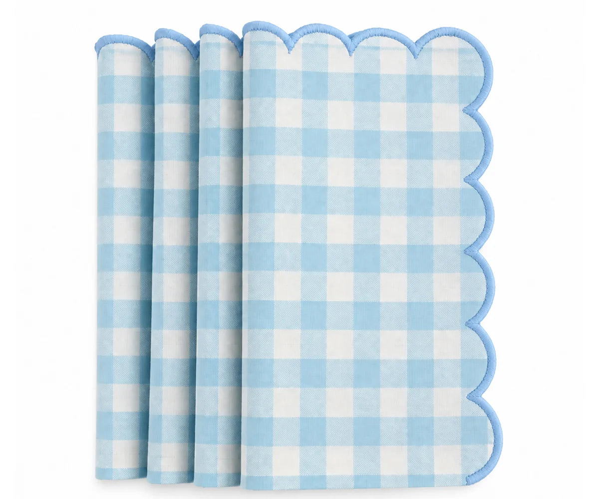 A stack of light blue and white gingham check paper napkins with scalloped edges, shown on a clean white background. A stack of light blue and white gingham check paper napkins with scalloped edges, shown on a clean white background.