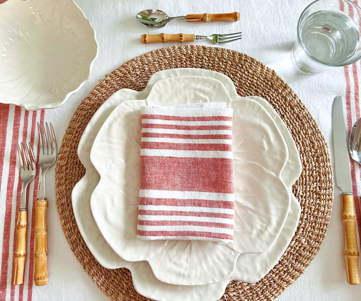A table setting with a red and white striped linen napkin arranged neatly A table setting with a red and white striped linen napkin arranged neatly