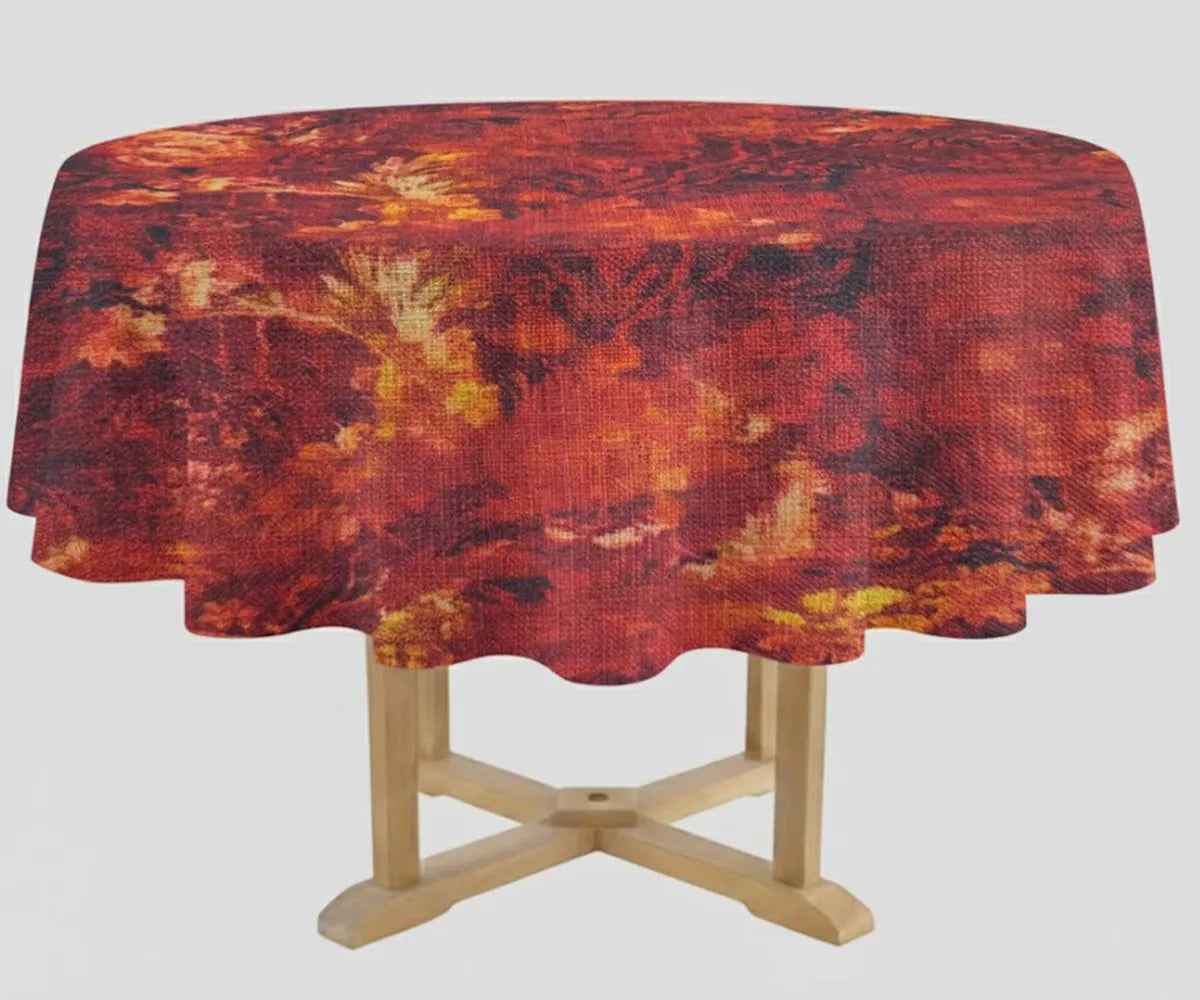 Round wooden table with a scalloped edge, covered in a dark red and burgundy floral-patterned tablecloth with warm orange and golden accents, set against a plain light background. Round wooden table with a scalloped edge, covered in a dark red and burgundy floral-patterned tablecloth with warm orange and golden accents, set against a plain light background.