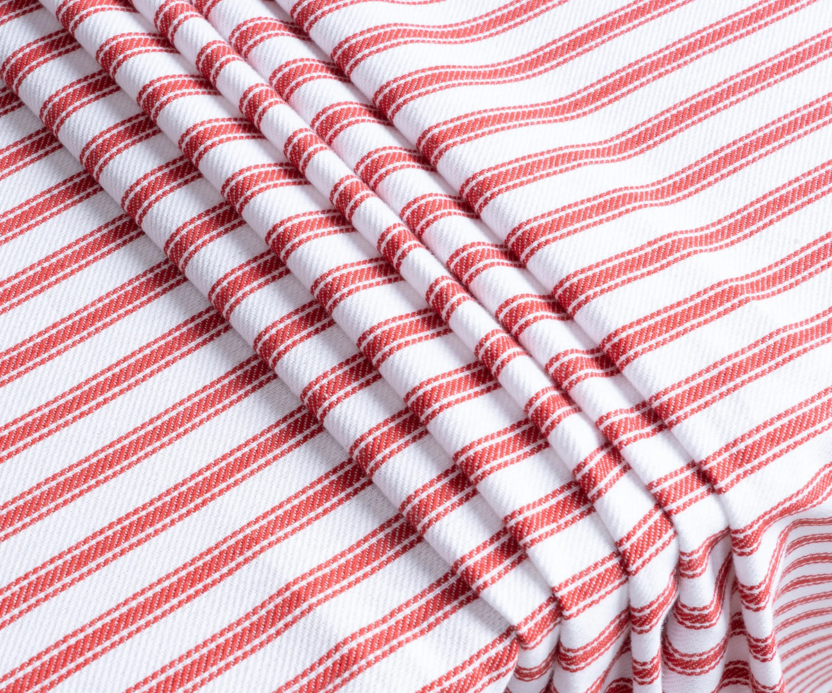 63-inch round red ticking stripe tablecloth styled for a festive gathering with layered table decor 63-inch round red ticking stripe tablecloth styled for a festive gathering with layered table decor