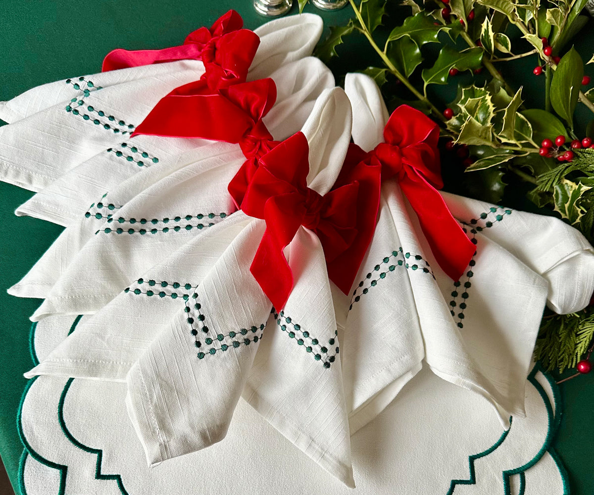 Elegant white napkin decorated with green embroidery Elegant white napkin decorated with green embroidery