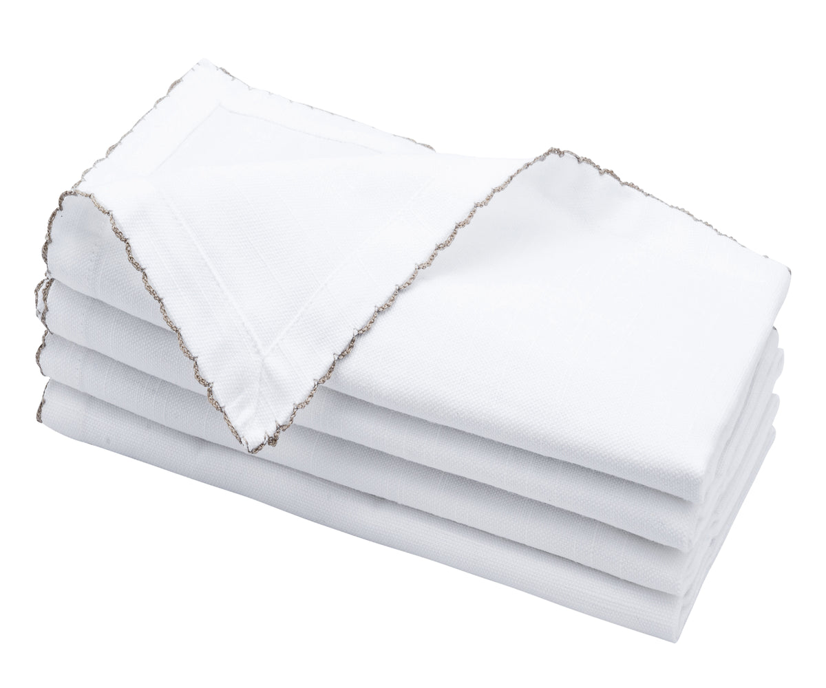 White napkin corner highlighted with beige decorative bunting stitch. White napkin corner highlighted with beige decorative bunting stitch.