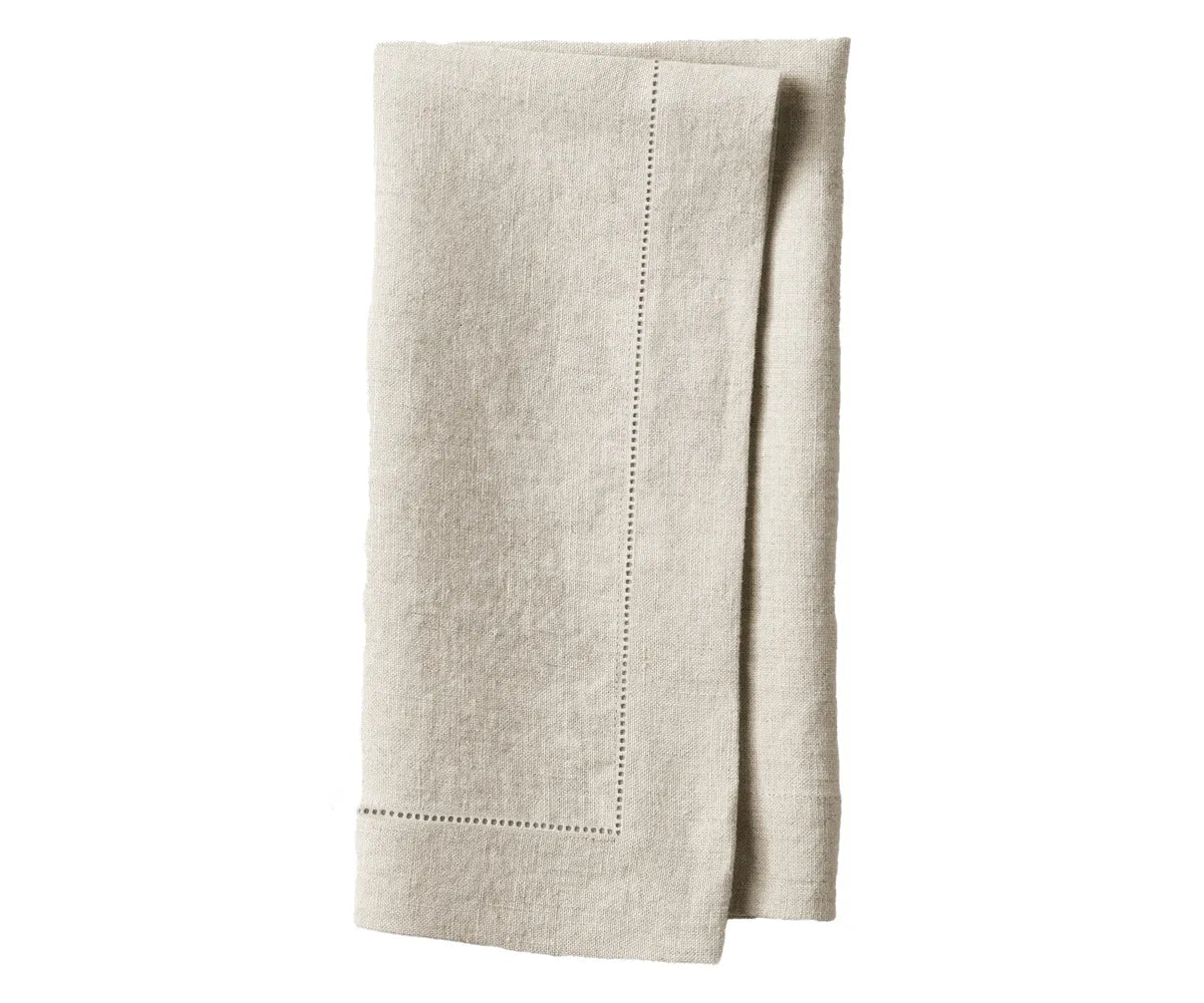 White linen napkins styled with gold cutlery and flower centerpiece. White linen napkins styled with gold cutlery and flower centerpiece.