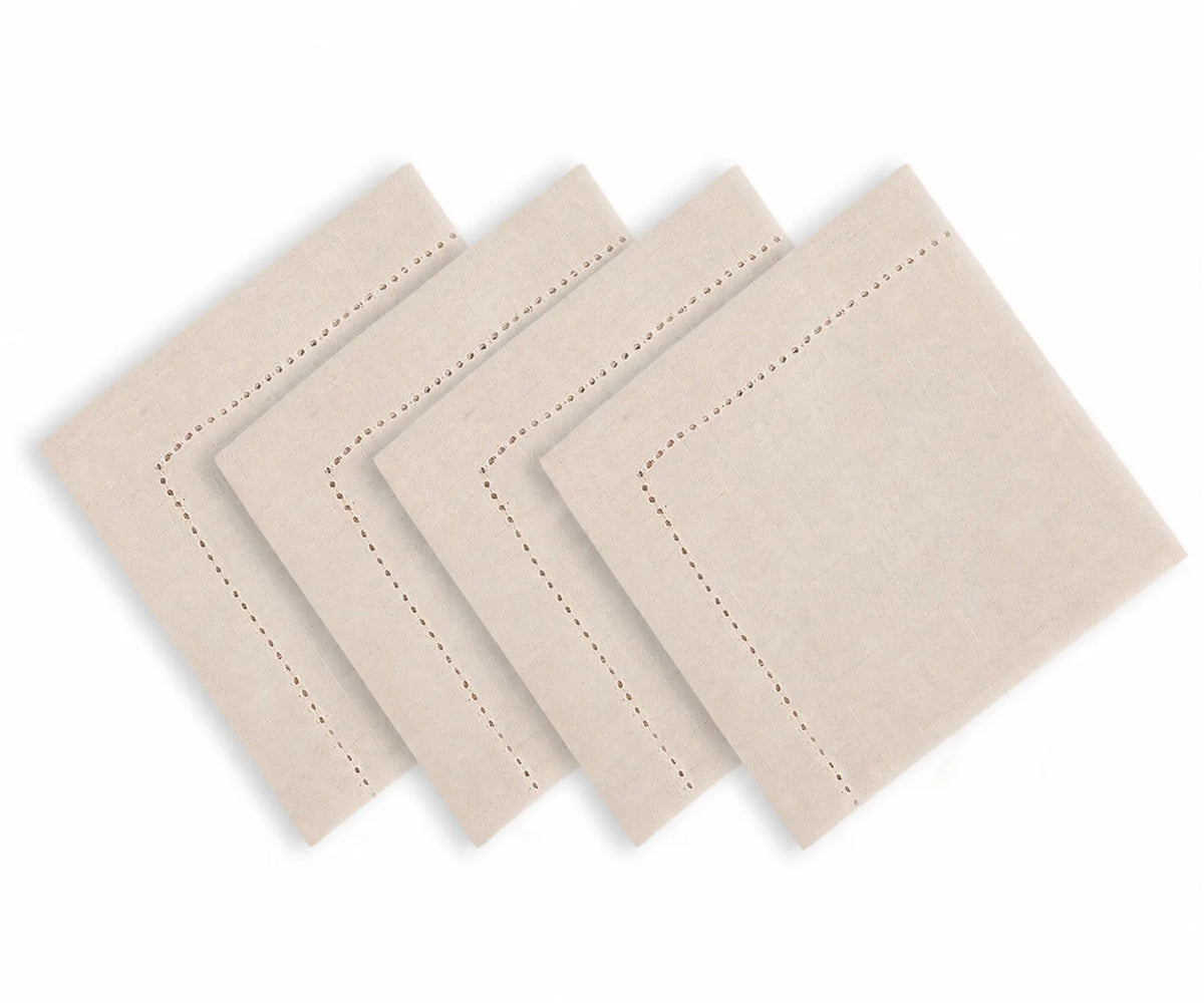 Natural color hemstitched cotton linen blend dinner napkins arranged on an elegant dining table with classic dinnerware and neutral table decor Natural color hemstitched cotton linen blend dinner napkins arranged on an elegant dining table with classic dinnerware and neutral table decor