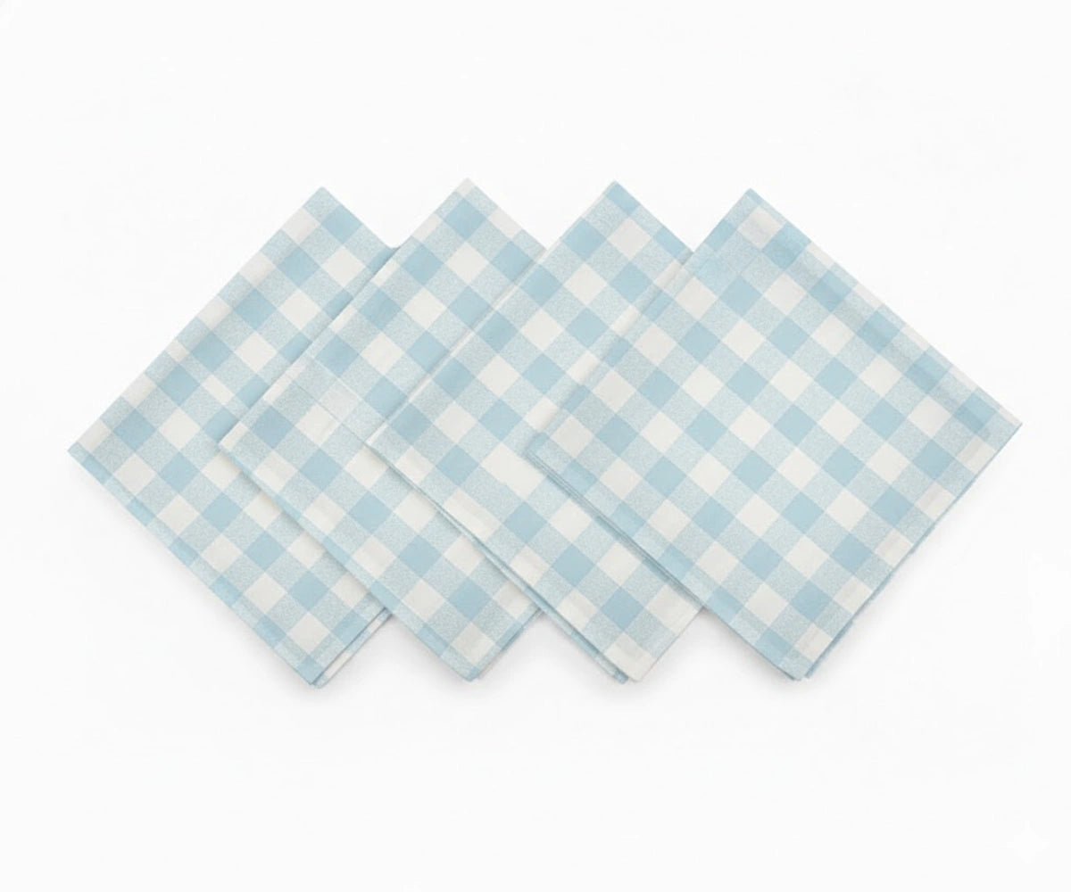 Set of light blue and white checked cotton napkins laid flat Set of light blue and white checked cotton napkins laid flat