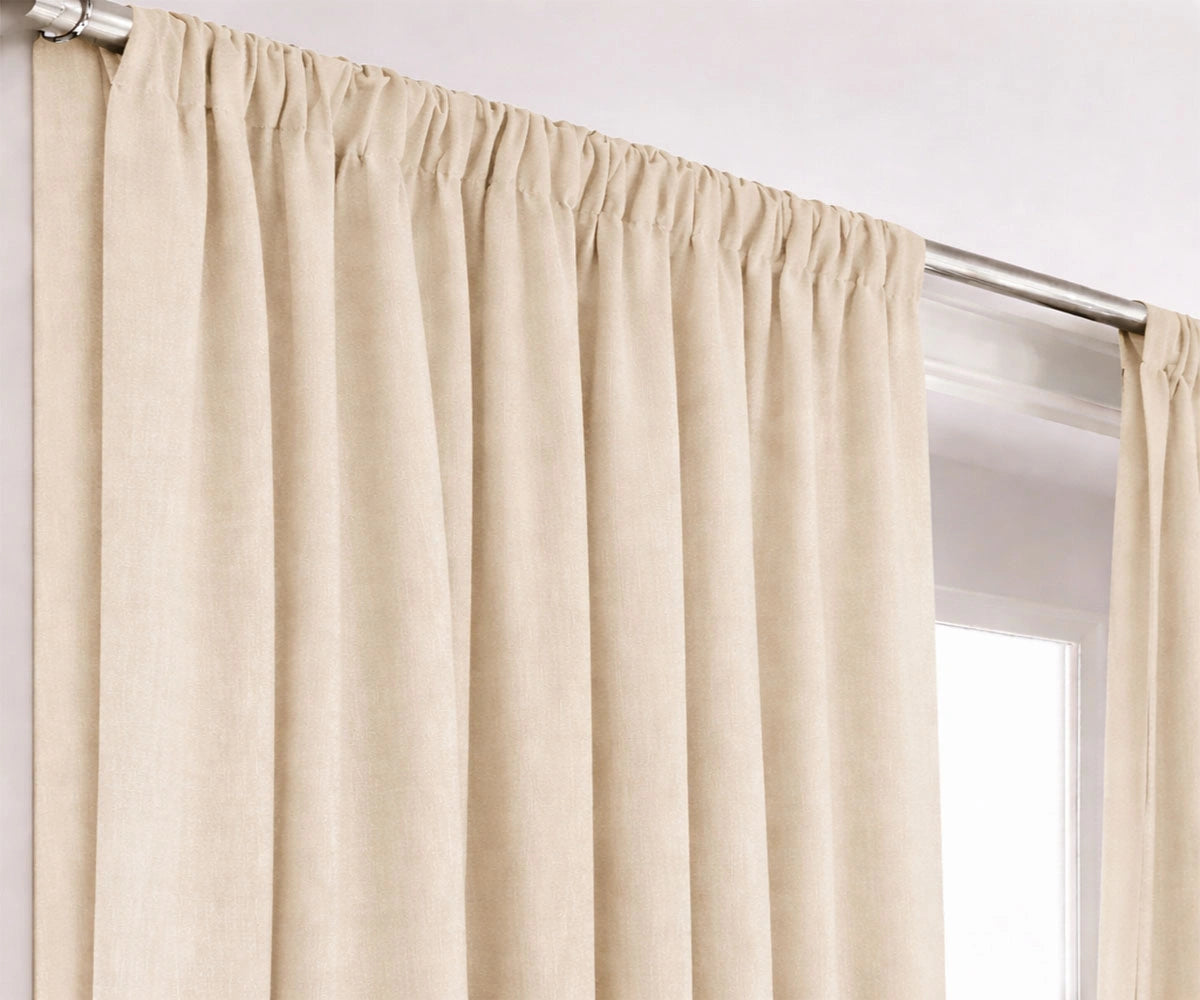 Neutral cream cotton curtains hanging on window rod Neutral cream cotton curtains hanging on window rod
