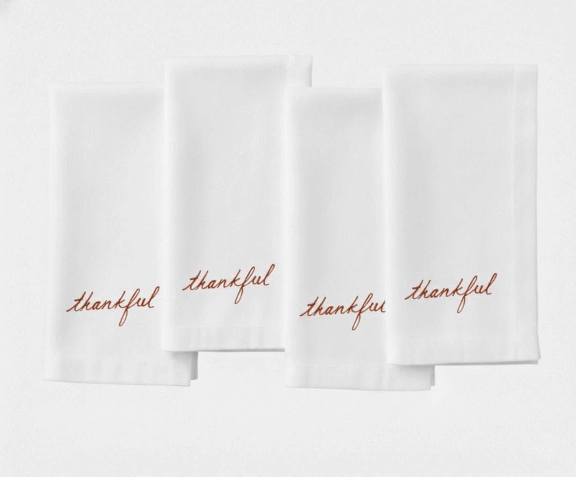 Classic white dinner napkin featuring stylish ‘Thankful’ stitched lettering. Classic white dinner napkin featuring stylish ‘Thankful’ stitched lettering.