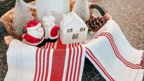 A trio of plush white kitchen towels featuring vibrant red stripes