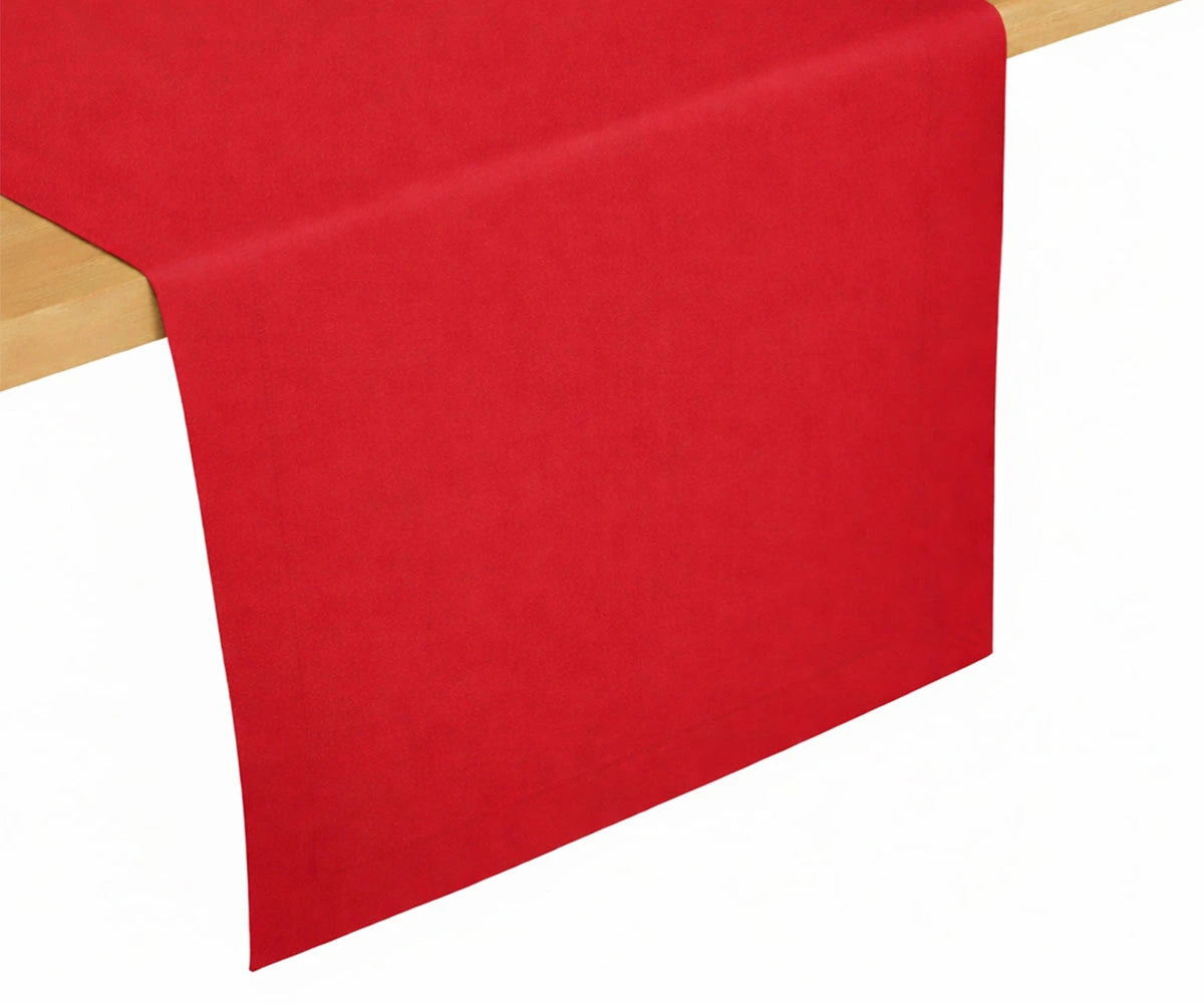 Red cotton table runner draped over a wooden dining table, solid color design for everyday dining and festive table décor Red cotton table runner draped over a wooden dining table, solid color design for everyday dining and festive table décor