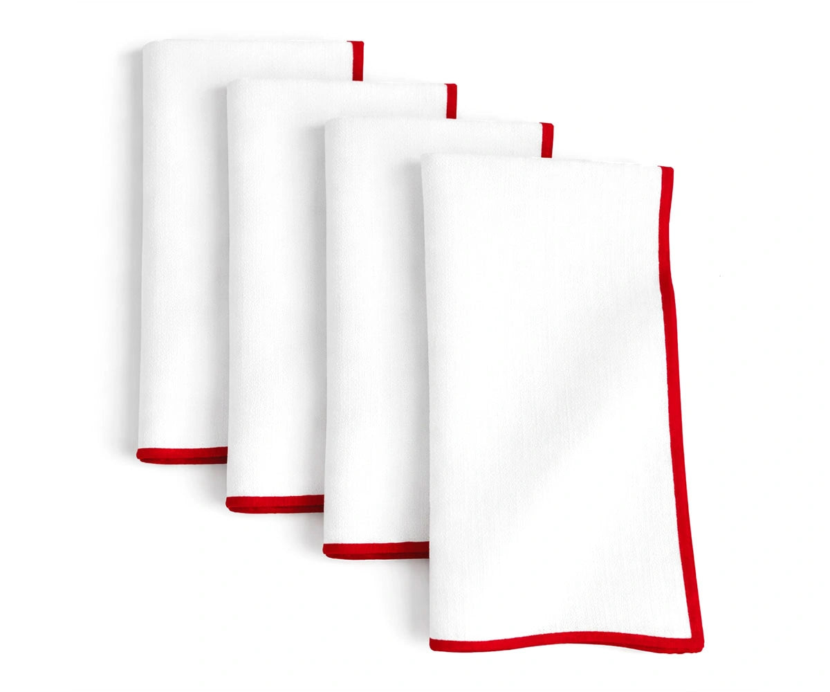 White embroidered cotton napkins accented with a vibrant red merrow edge White embroidered cotton napkins accented with a vibrant red merrow edge