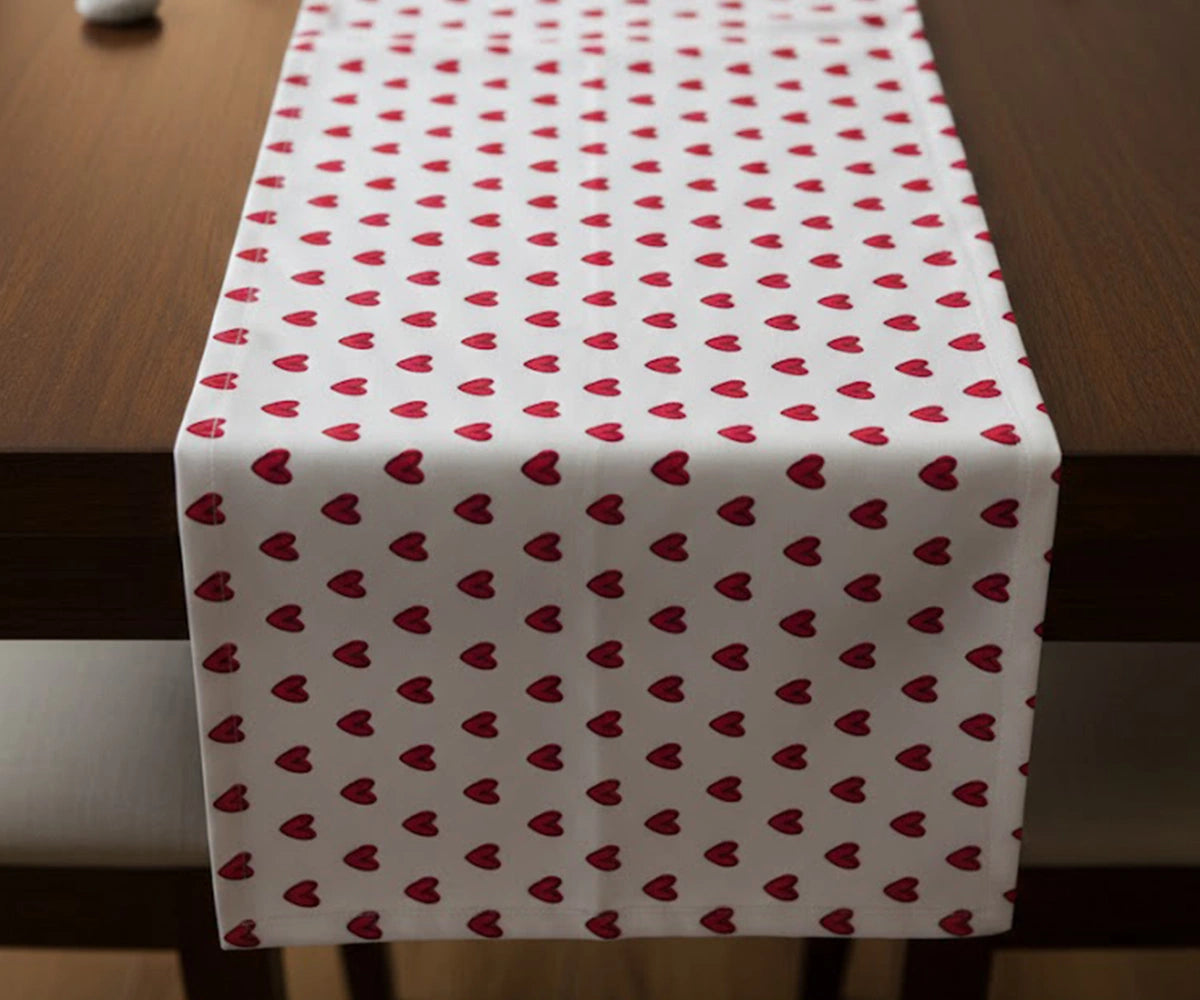 White tablecloth with small red heart pattern draped over a rectangular table White tablecloth with small red heart pattern draped over a rectangular table