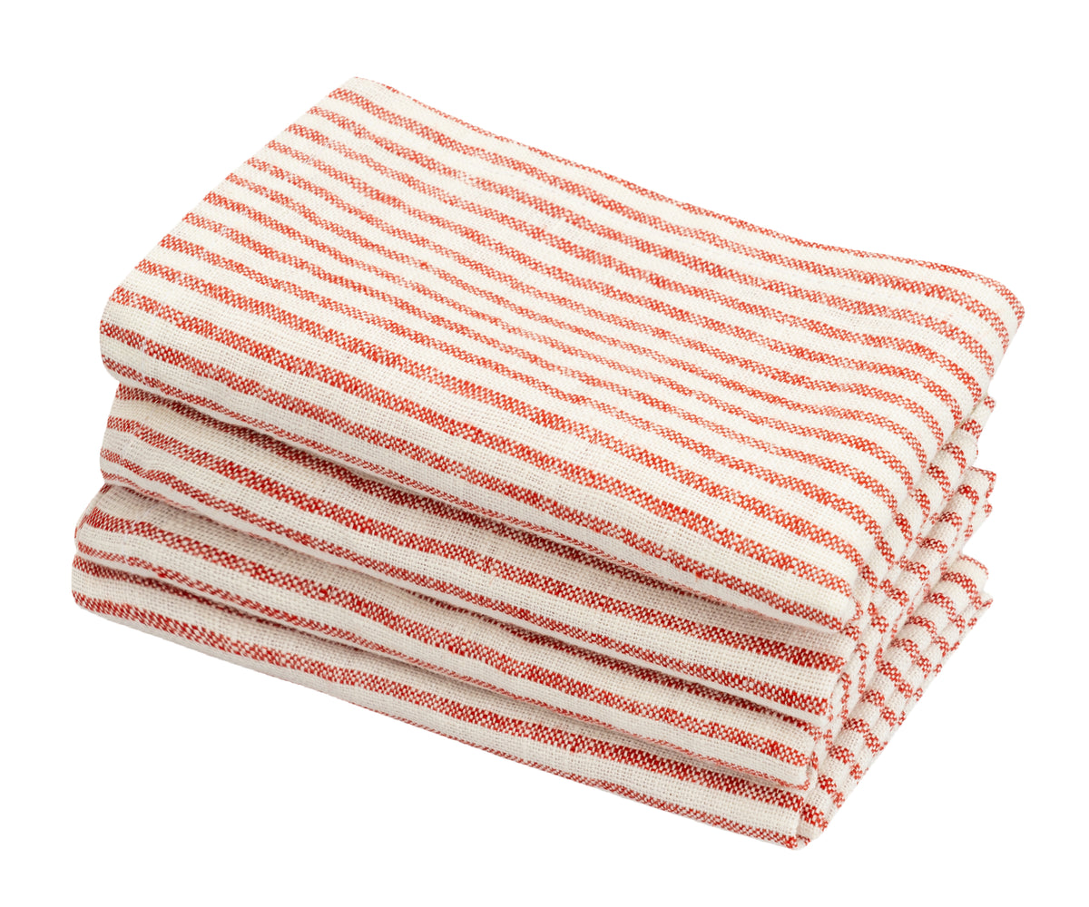 Linen napkins draped over a table edge to show soft and durable fabric texture Linen napkins draped over a table edge to show soft and durable fabric texture