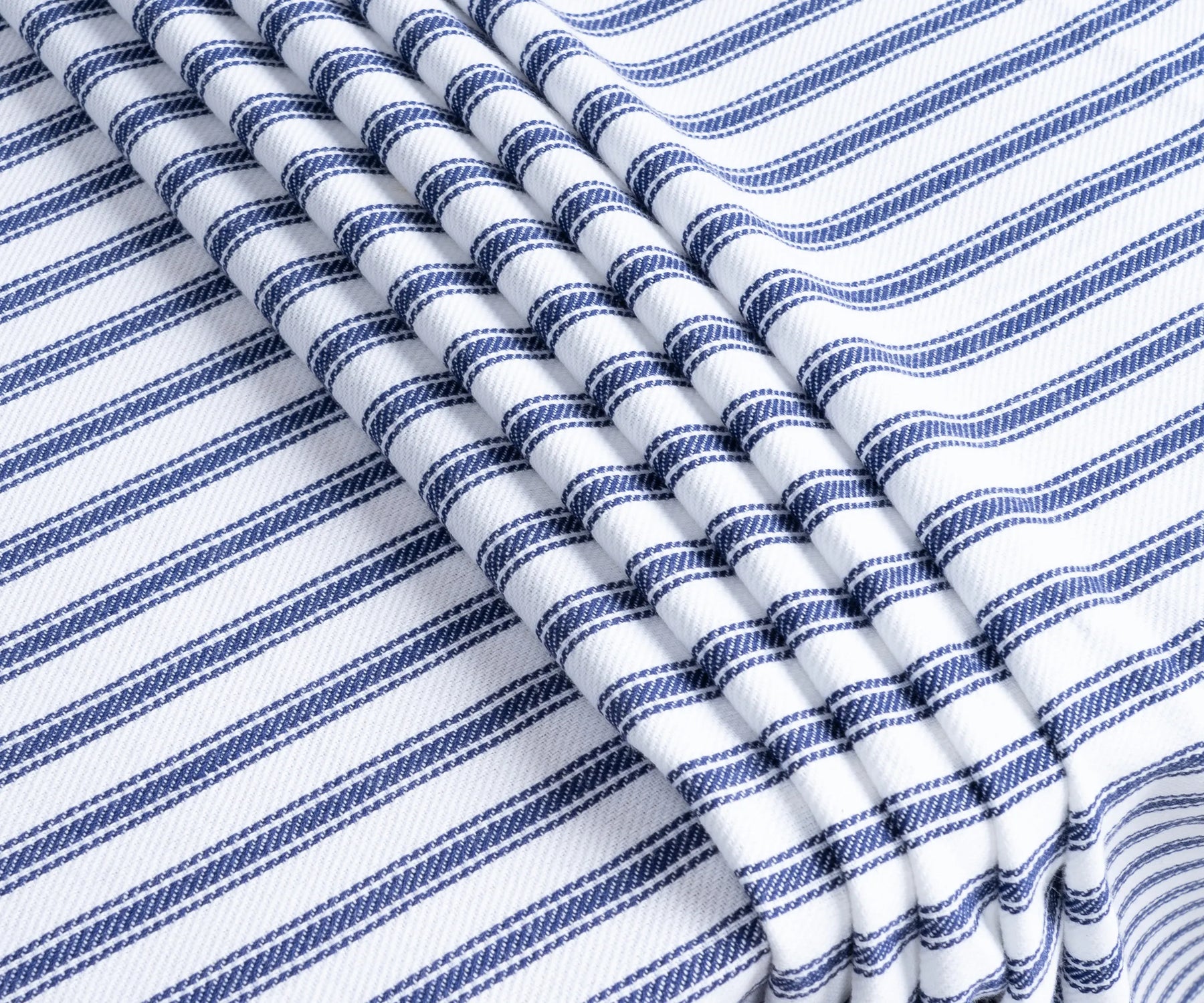 Folded blue and white striped round tablecloth showcasing fabric texture Folded blue and white striped round tablecloth showcasing fabric texture