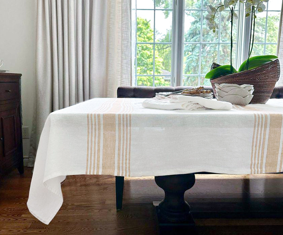 White linen-covered dining table with a rustic brown vase as decor White linen-covered dining table with a rustic brown vase as decor