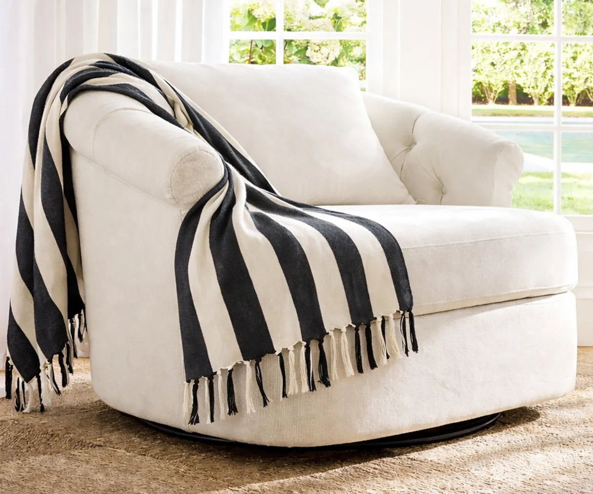 Decorative striped throw blanket placed on a cozy chair adding warmth and texture to a modern living room Decorative striped throw blanket placed on a cozy chair adding warmth and texture to a modern living room