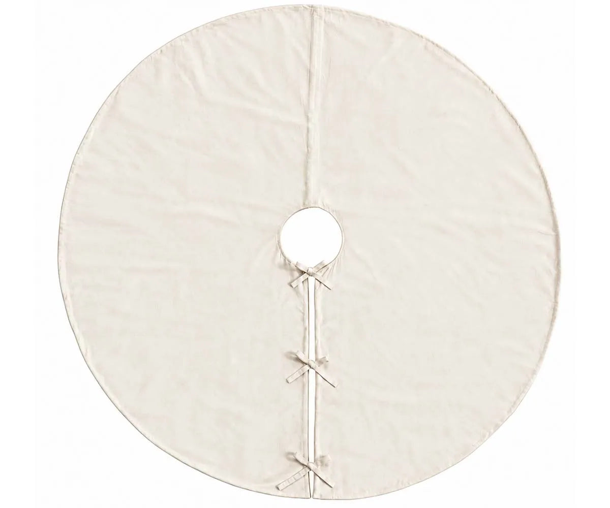 Plain ivory linen tree skirt placed around the base of a Christmas tree for a neutral look Plain ivory linen tree skirt placed around the base of a Christmas tree for a neutral look