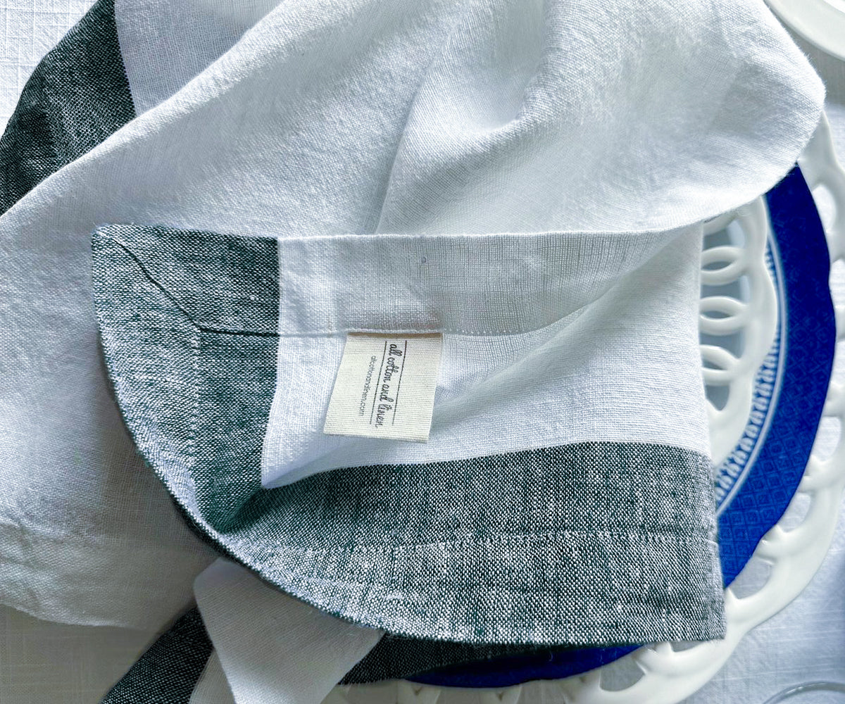 Several folded cloth napkins and linen cocktail napkins on a ceramic tray Several folded cloth napkins and linen cocktail napkins on a ceramic tray