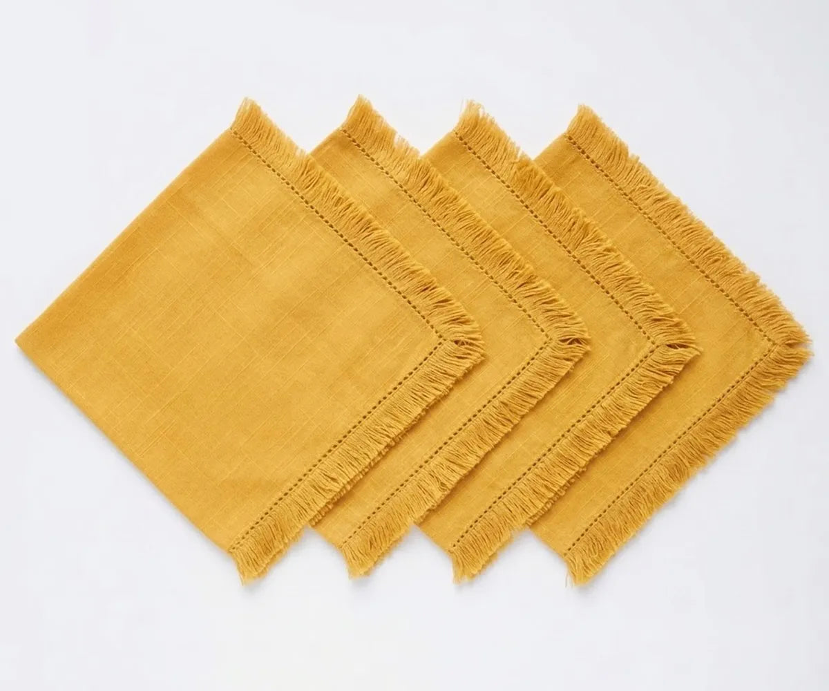 Elegant cotton table napkins with decorative fringe edges, designed for stylish place settings and dining decor. Elegant cotton table napkins with decorative fringe edges, designed for stylish place settings and dining decor.