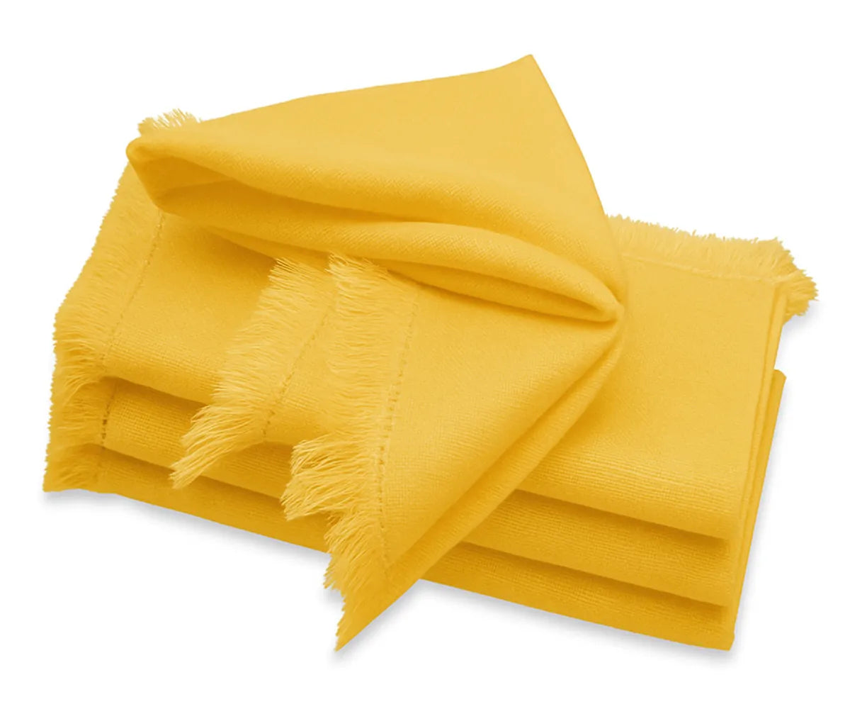 Yellow cotton fringe napkin neatly folded on a dining table for wedding or party setup. Yellow cotton fringe napkin neatly folded on a dining table for wedding or party setup.