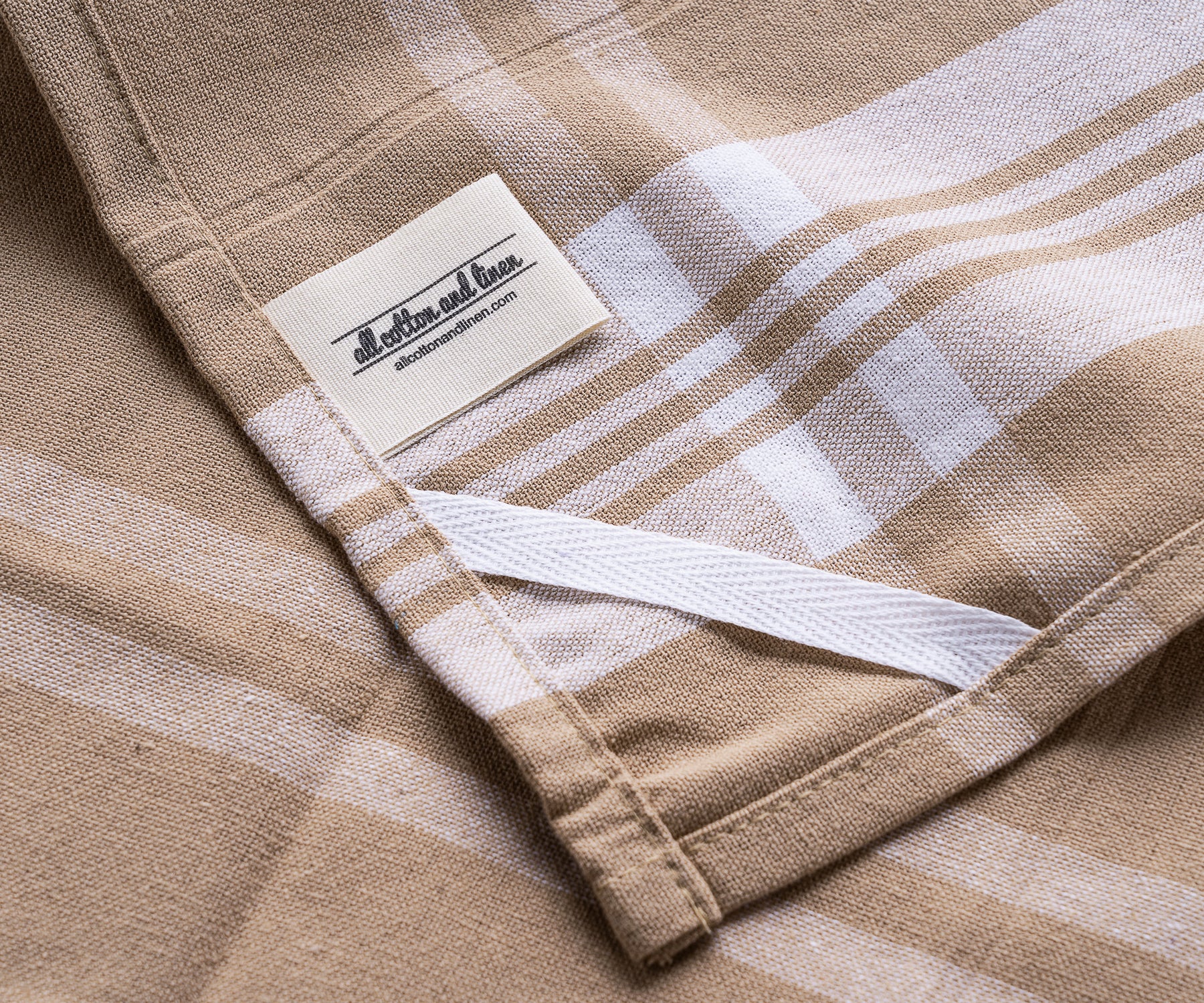 Close-up of a farmhouse kitchen hand towel with a tan and white checkered pattern Close-up of a farmhouse kitchen hand towel with a tan and white checkered pattern
