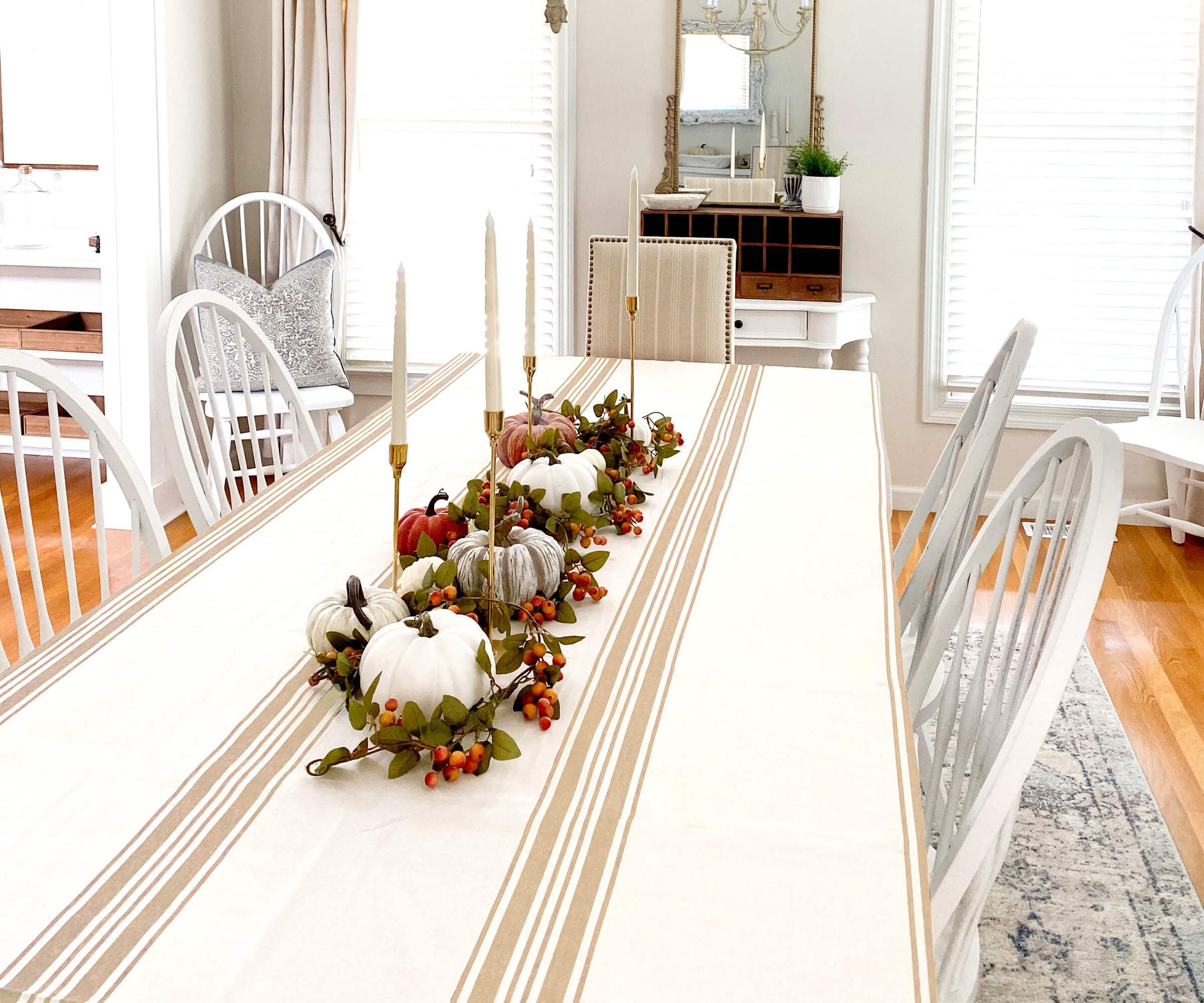Farmhouse tablecloth on a dining table with white chairs