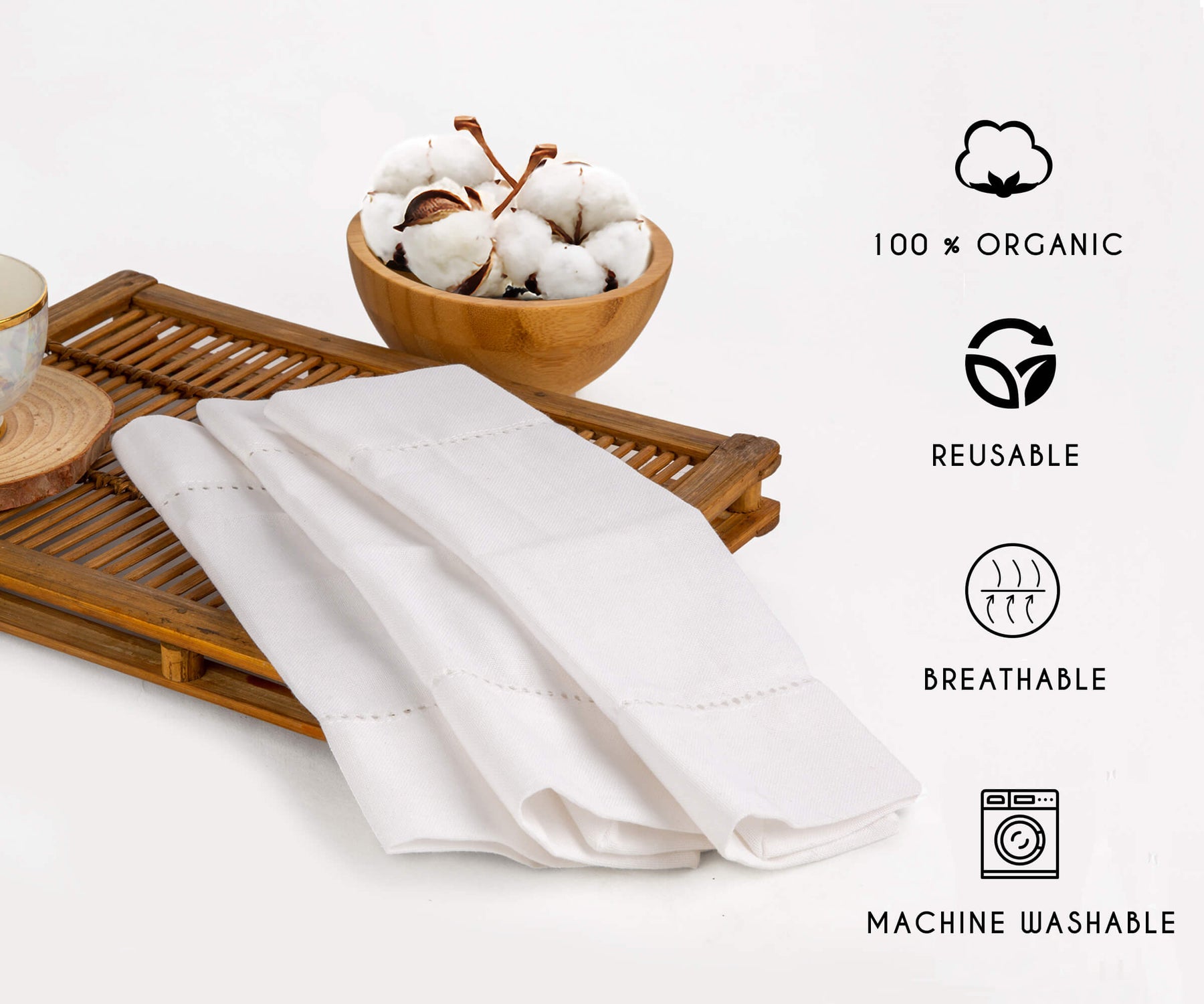 White napkins with borders are placed on the wooden box showing characteristics like organic, reusable, breathable, Machine washable. White napkins with borders are placed on the wooden box showing characteristics like organic, reusable, breathable, Machine washable.
