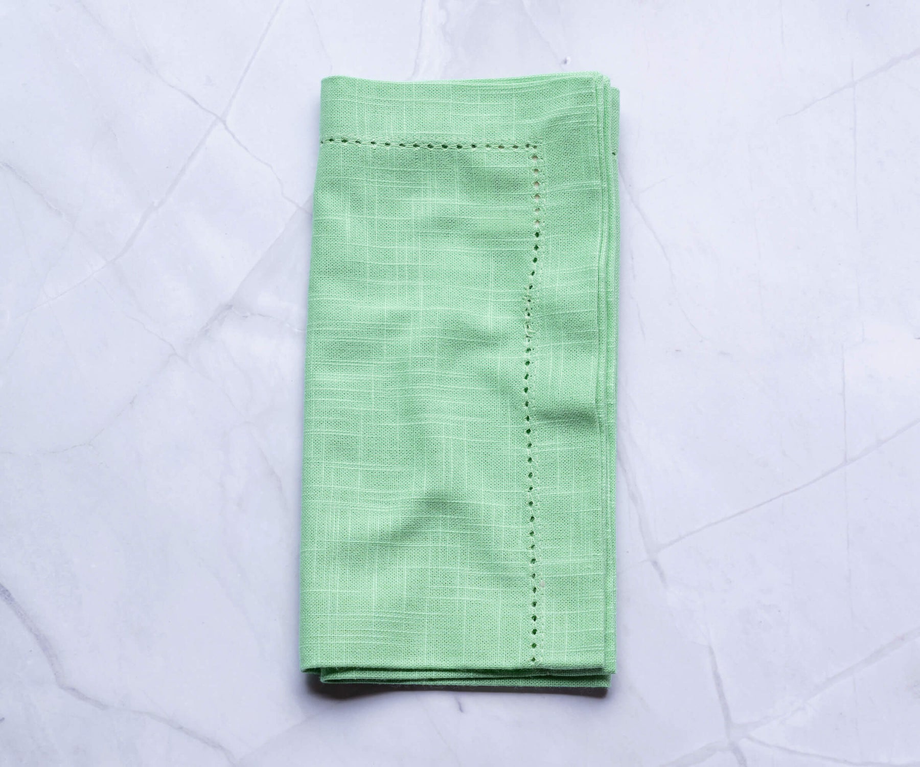 Eton green-colored cloth napkins, easter dinner napkins with borders are folded and placed on the white floor. Eton green-colored cloth napkins, easter dinner napkins with borders are folded and placed on the white floor.