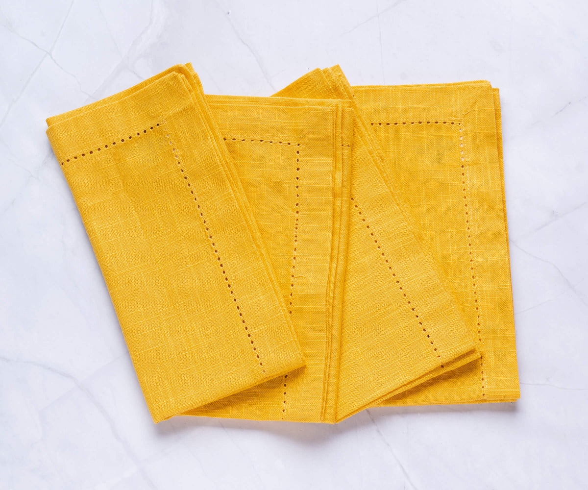 Hemstitched Folded yellow cloth napkins with 1 Hemstitched Folded yellow cloth napkins with 1