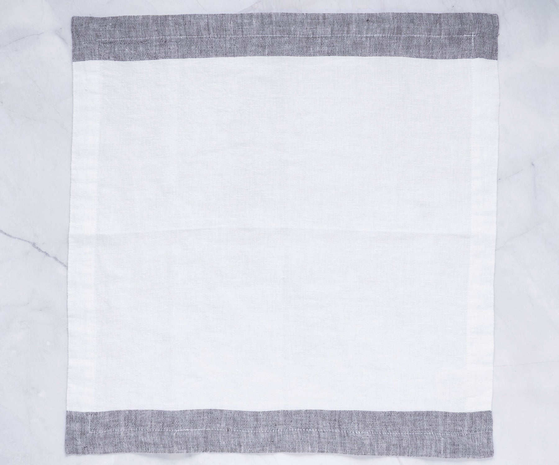 Freshly laundered white linen dinner napkins stacked high Freshly laundered white linen dinner napkins stacked high