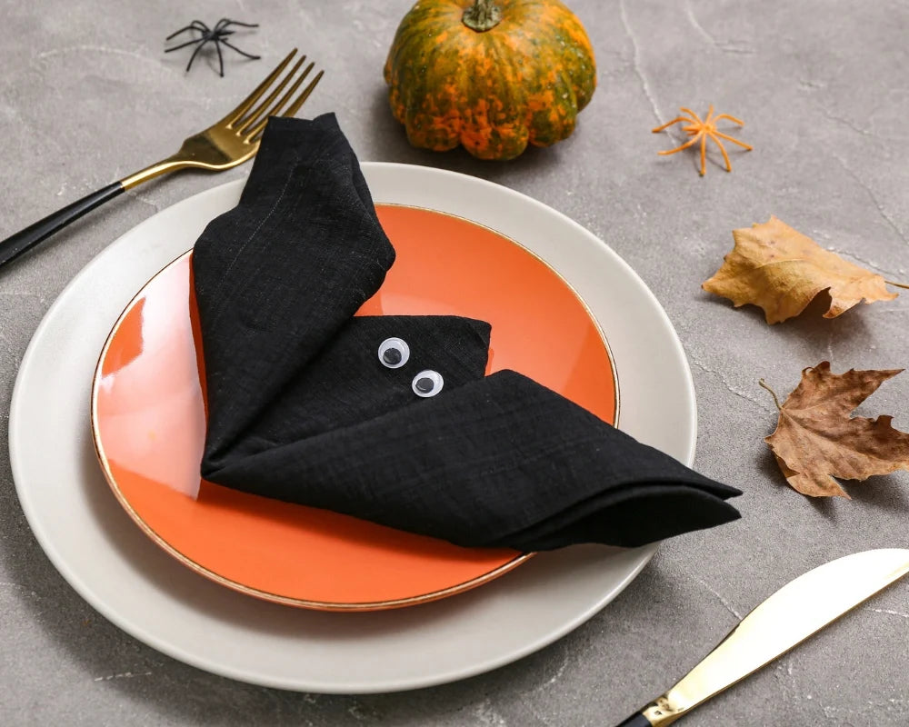  Halloween dinner table with cloth napkins folded into a bat.