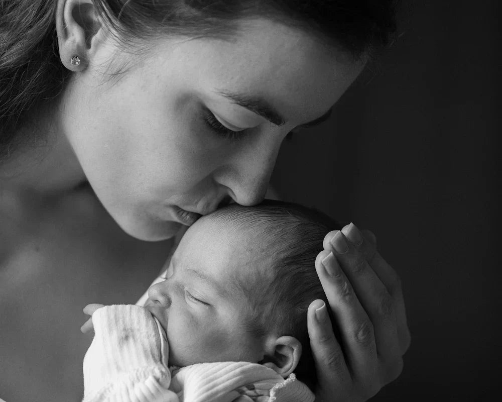 a woman holding her new born baby to represent her new motherhood