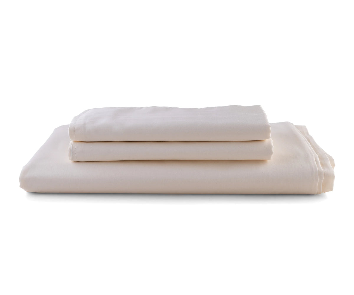 king size cotton sateen flat sheet in natural color neatly spread on a bed
