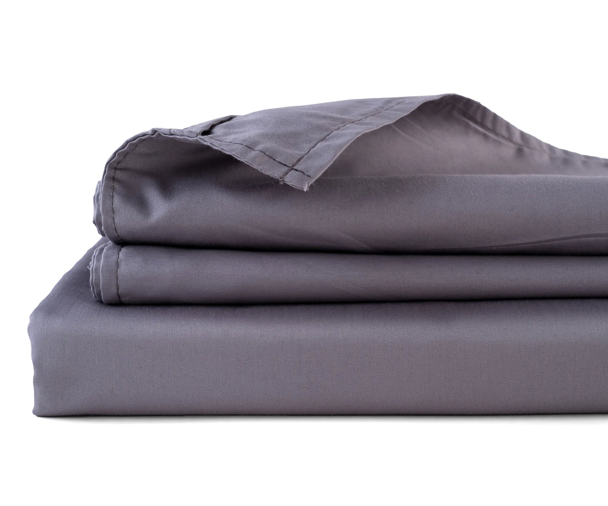   grey cotton sateen flat sheet neatly spread on a bed
