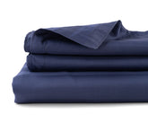 Striped cotton sateen flat sheet neatly spread on a bed in elegant pattern
