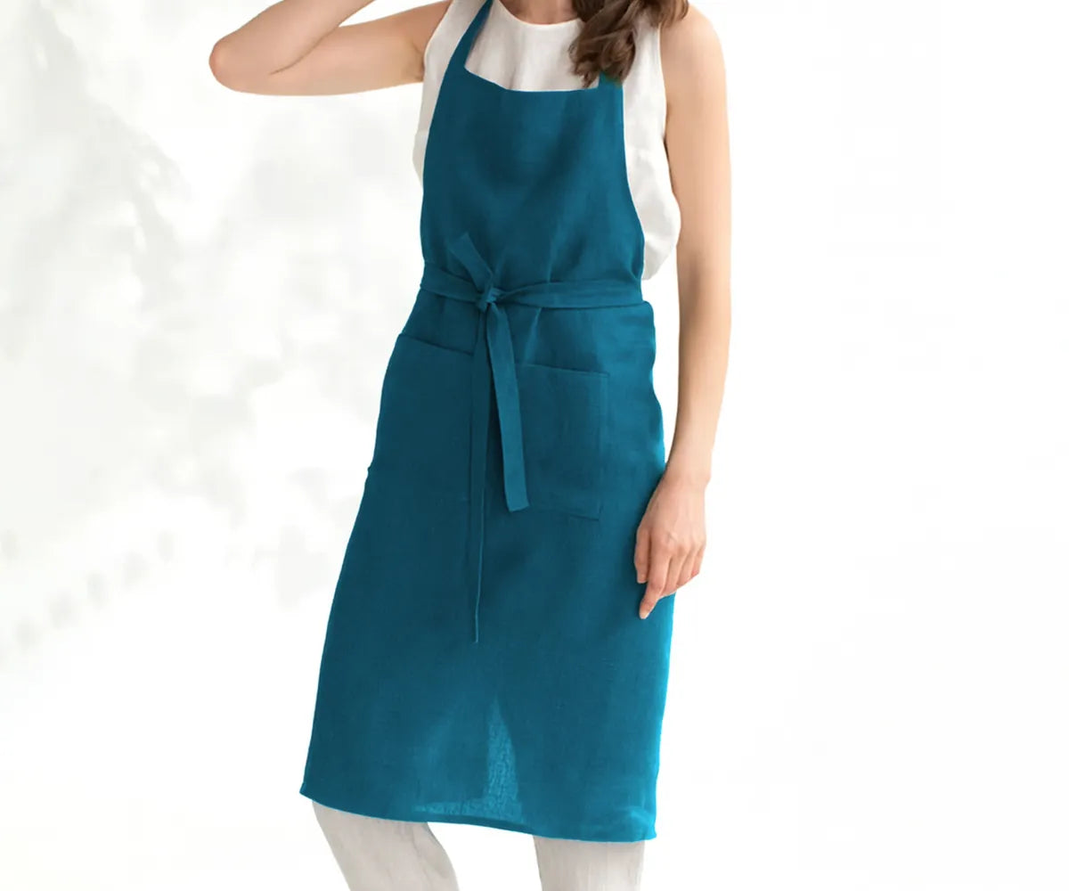 Teal linen apron made from breathable, durable fabric with adjustable neck strap and front pockets, designed for cooking, baking, gardening, and everyday kitchen use.