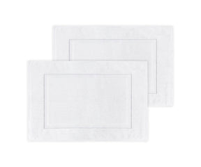 Two white bath mats with a subtle pattern on a white background