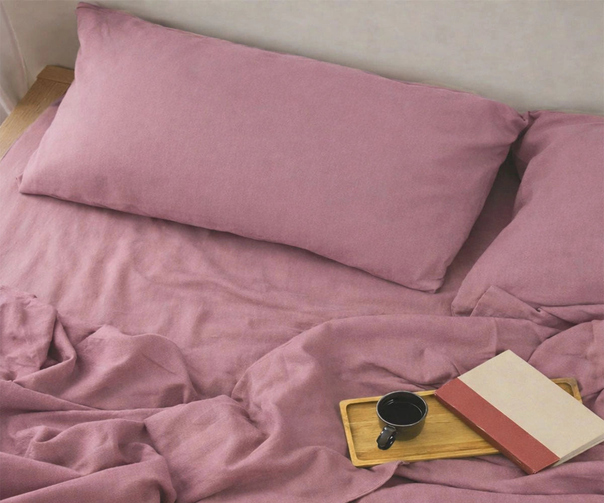 Soft dusty mauve 100 linen sheets styled on bed, natural affordable linen sheets for king and queen size mattresses, lightweight cooling bedding